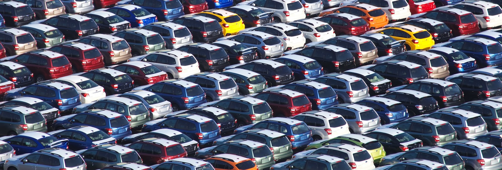 An aerial view of a car dealership's inventory lot filled with rows of various cars, illustrating effective car dealership inventory management strategies. This image highlights the importance of organized automotive dealership inventory management for optimal sales and customer satisfaction.